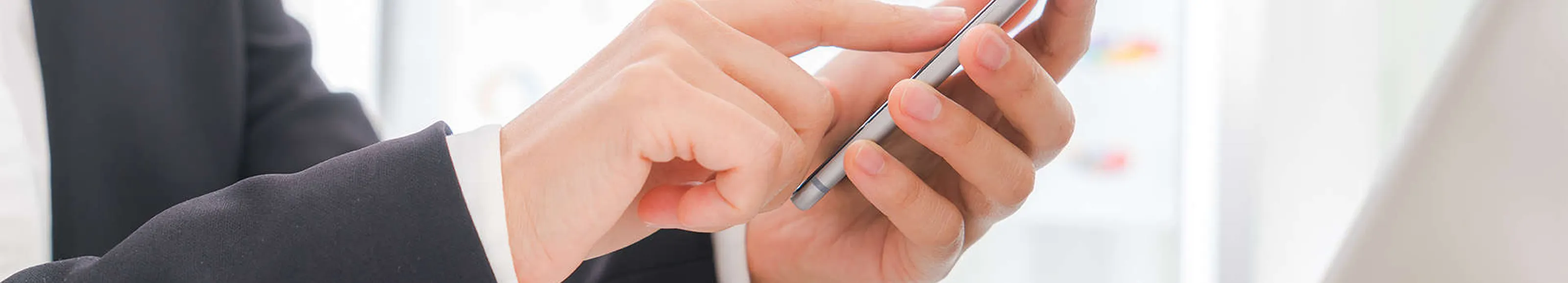 Person using a smartphone with a blurred office background
